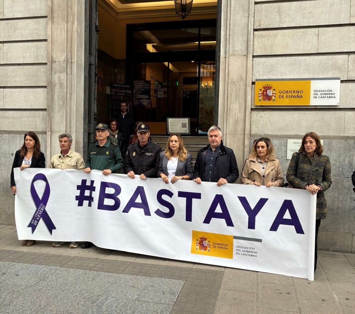 Personal de Delegación y fuerzas de seguridad sosteniendo la pancarta "# Basta Ya"
