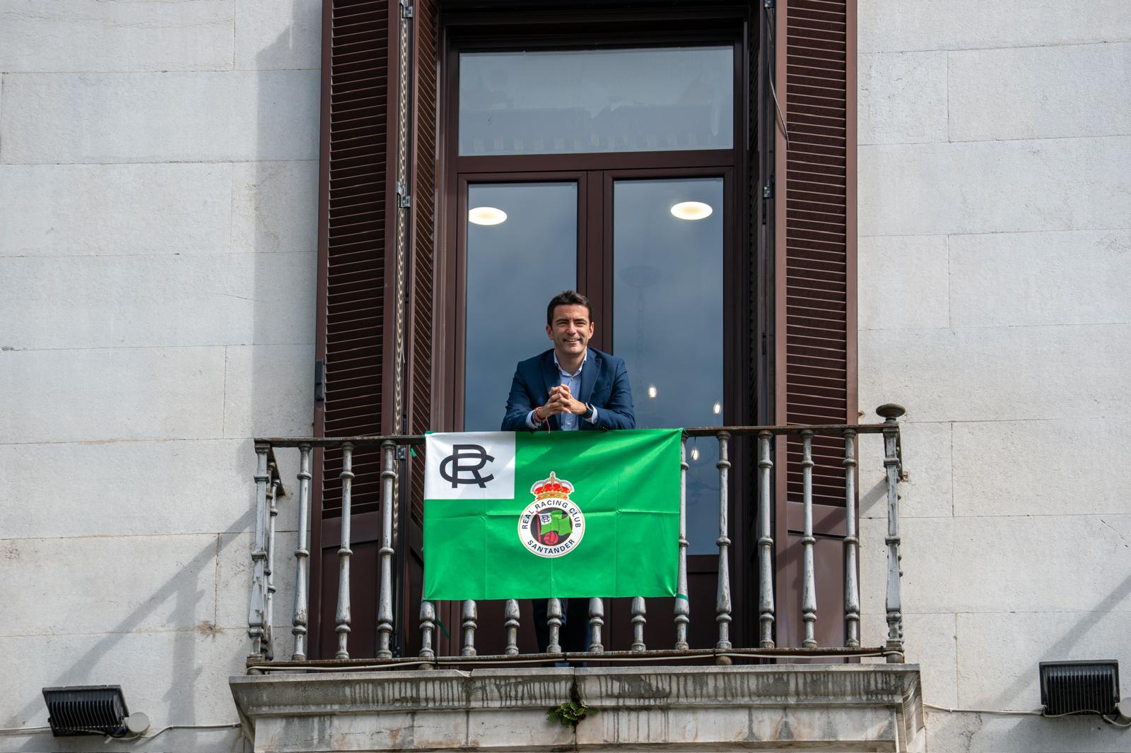El delegado en un balcón de la Delegación en la que se ha puesto una bandera del club