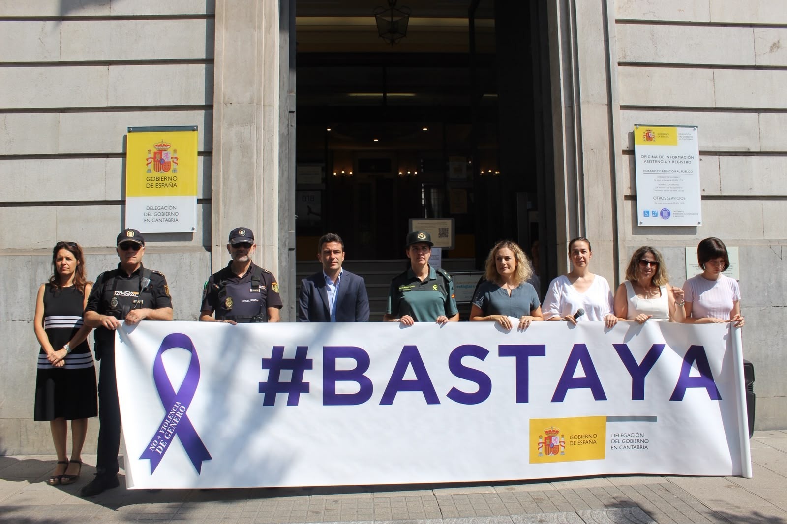 El delegado del Gobierno junto a otras autoridades en la puerta de la Delegación sosteniendo la pancarta #Basta Ya , durante el minuto de silencio