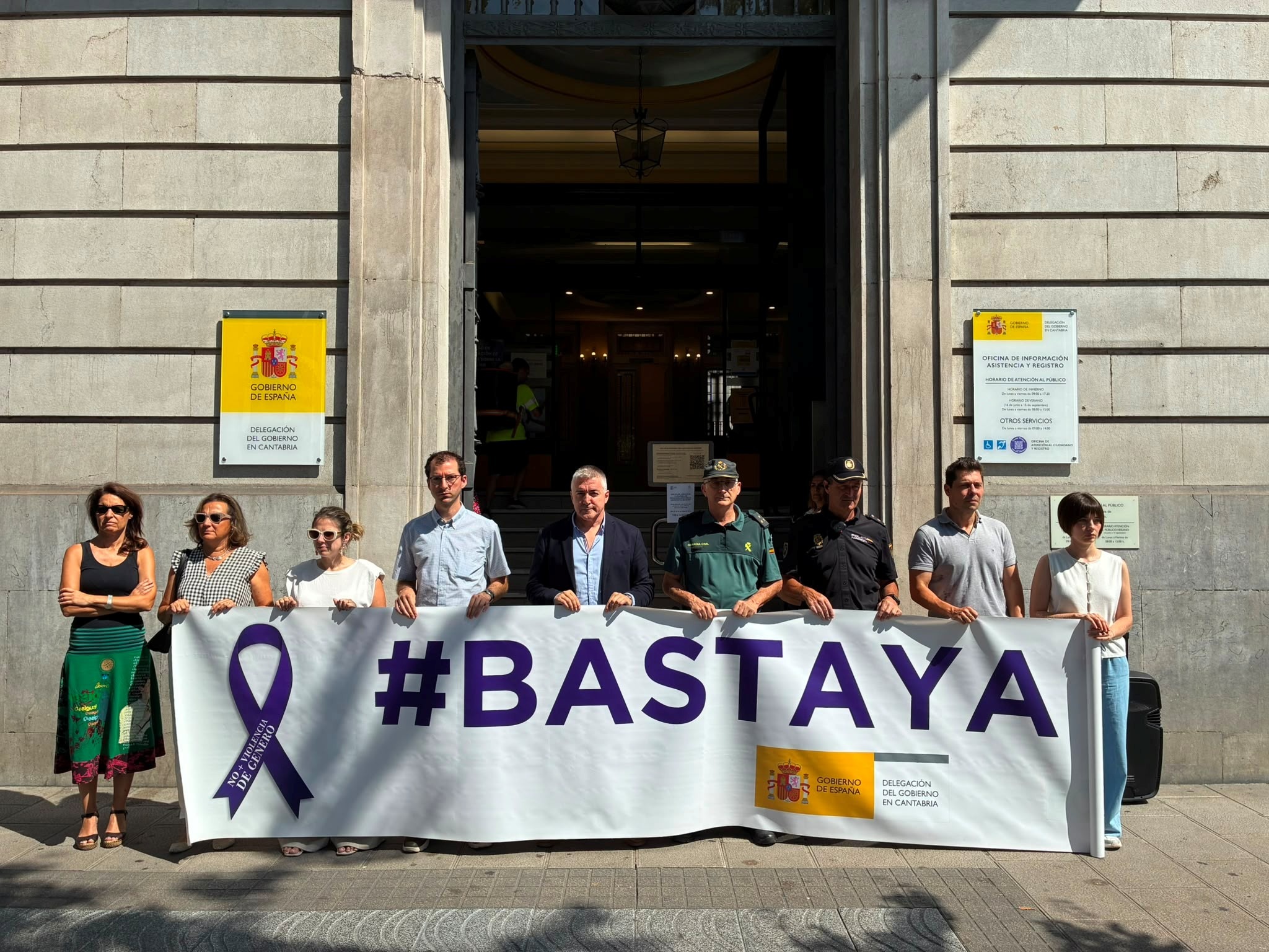 Personal de la Delegación sosteniendo la pancarta #Basta Ya , durante el minuto de silencio