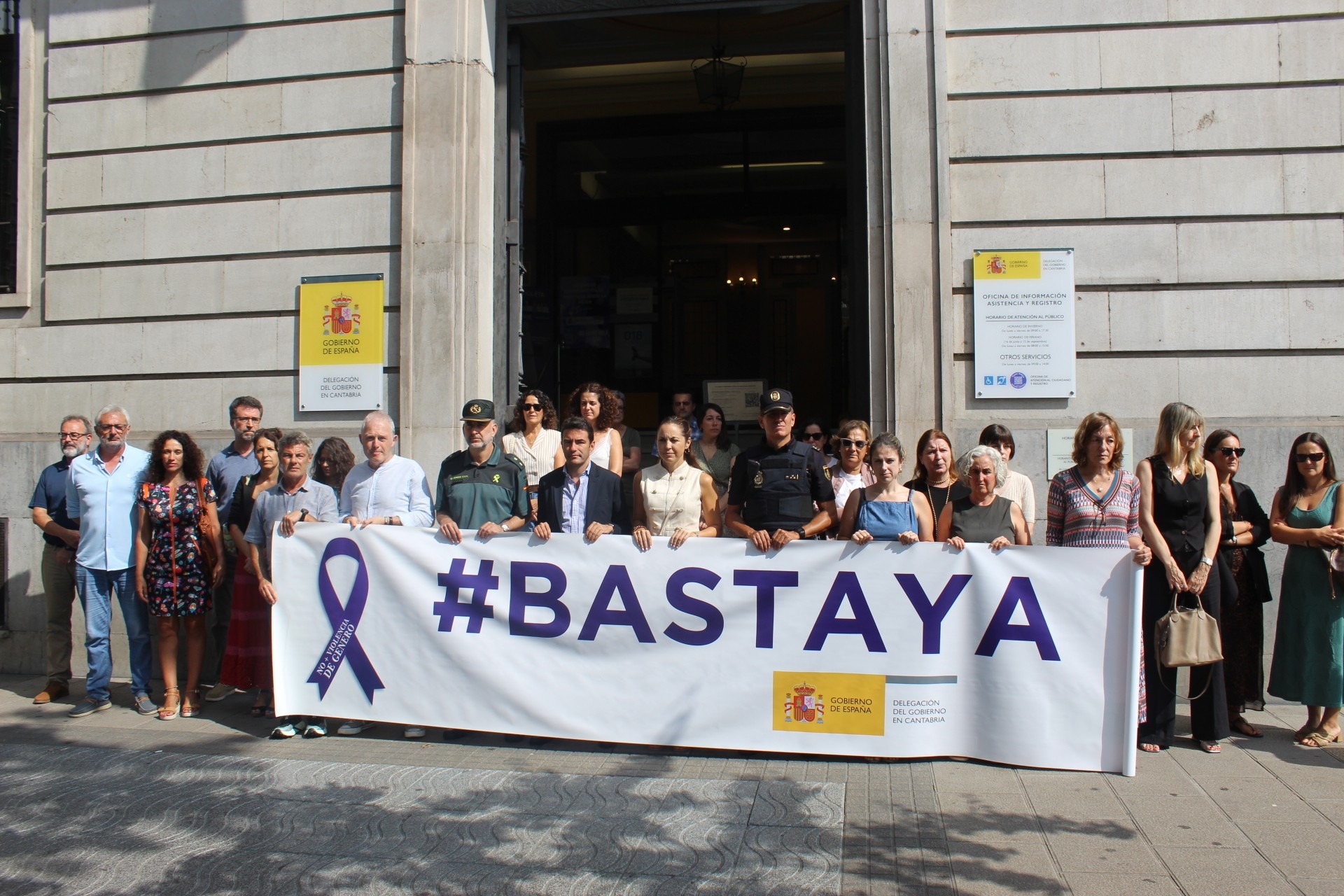 Imagen del minuto de silencio frente a la Delegación del Gobierno con la pancarta #BASTA YA