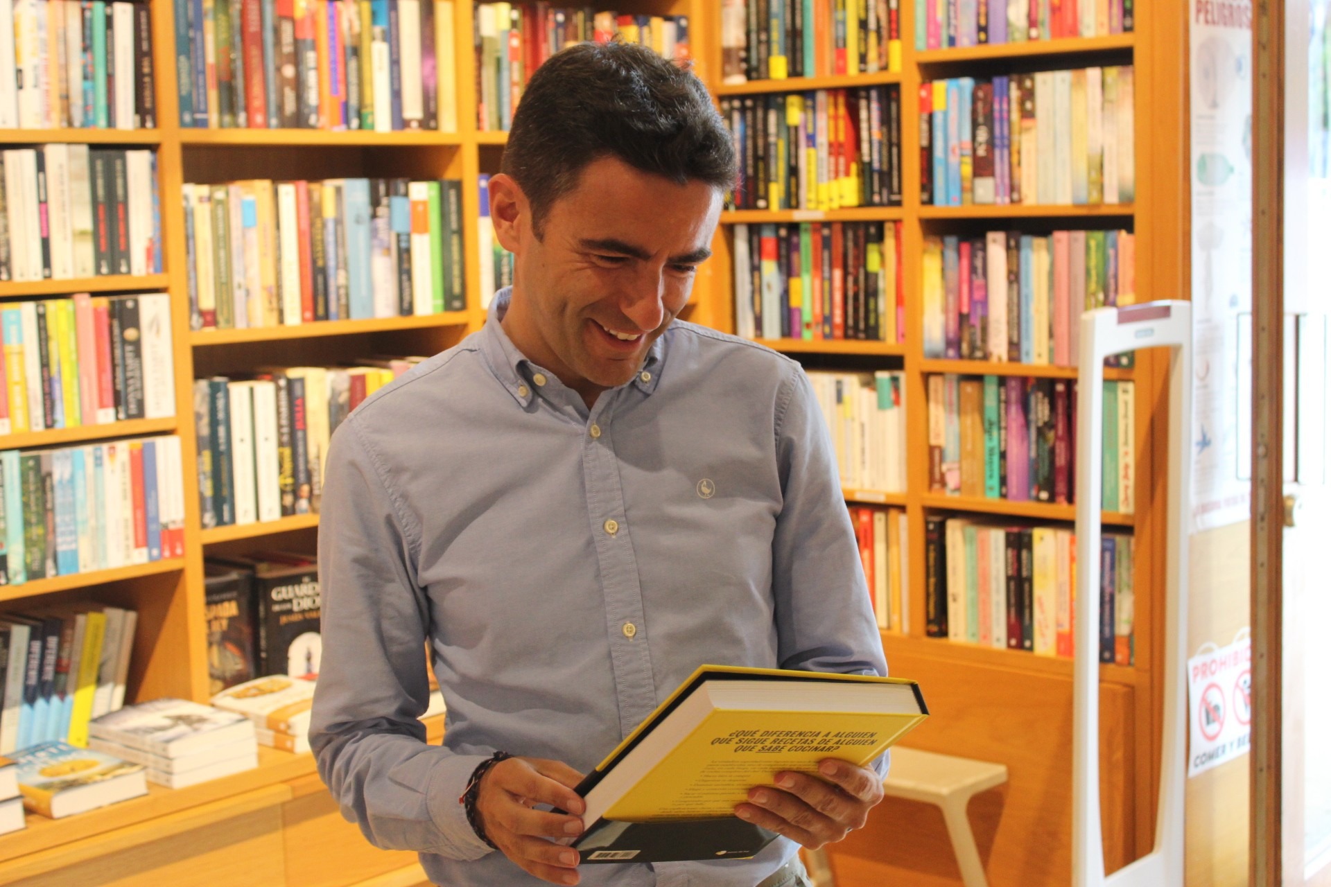 El delegado ojea un libro durante su visita a una librería