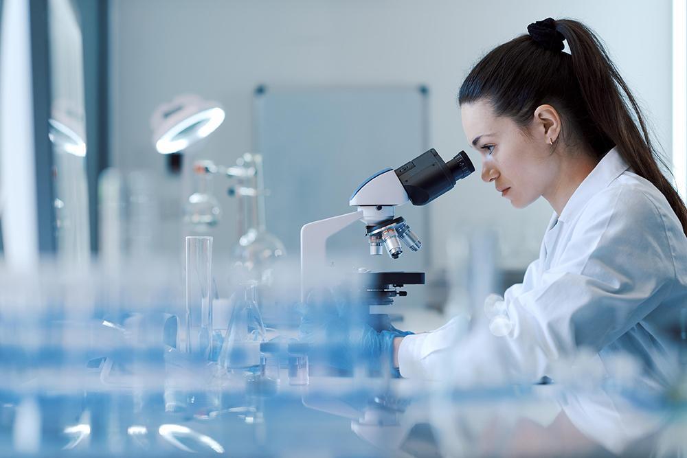 Persona trabajando con un microscopio en un laboratorio