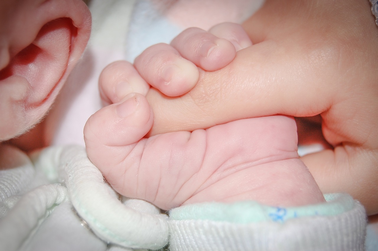 Mano de un bebé agarrando a su madre/padre