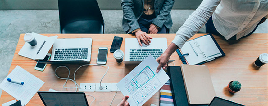 Bulegoko mahai batean lanean ari diren pertsonak