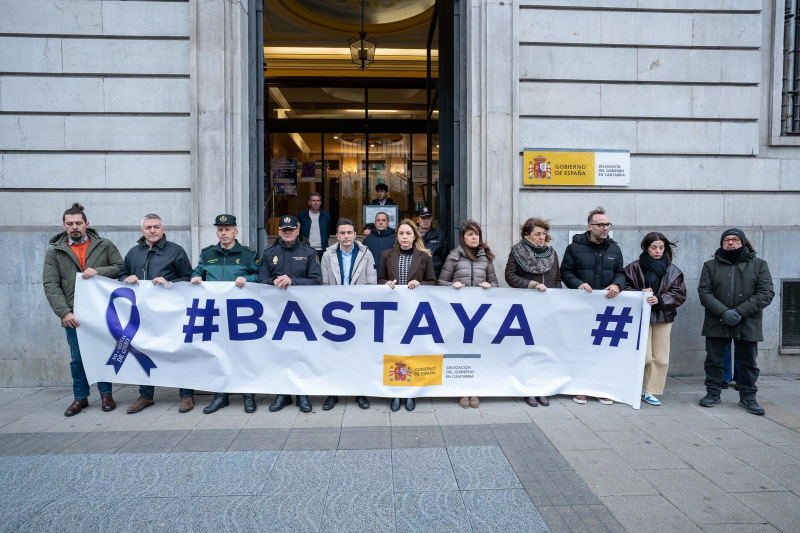 Autoridades y personal de la Delegación del Gobierno sosteniendo la pancarta Basta ya 