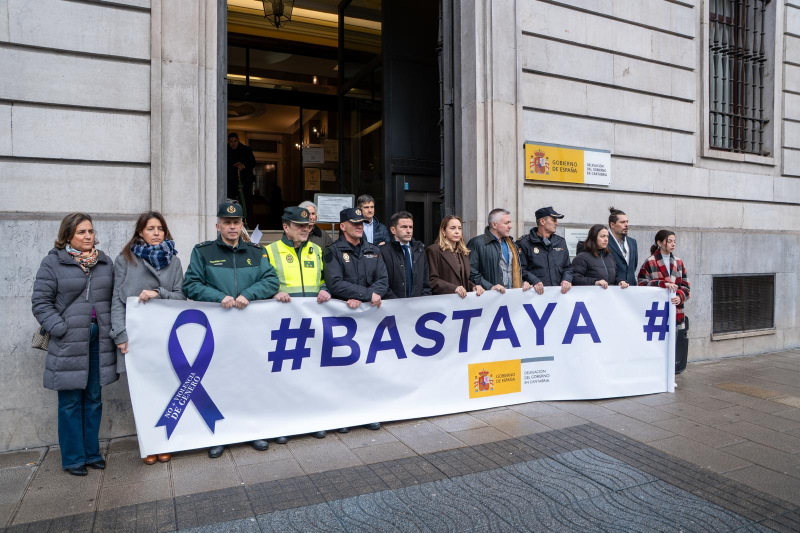 El Delegado del Gobierno en Cantabria junto a otras autoridades y funcionarios de la delegación del Gobierno manteniendo la pancarta BASTA YA