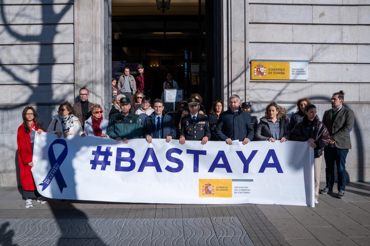El Delegado junto a otras autoridades y trabajadores de la Delegación del Gobierno manteniendo la pancarta Basta Ya