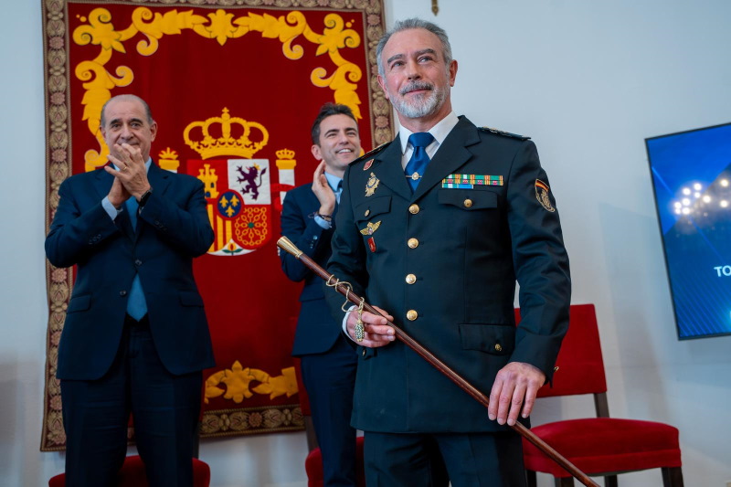 El nuevo Jefe Superior de Policía sosteniendo el bastón de mando y al fondo el director General de la Policía y el delegado del Gobierno en Cantabria