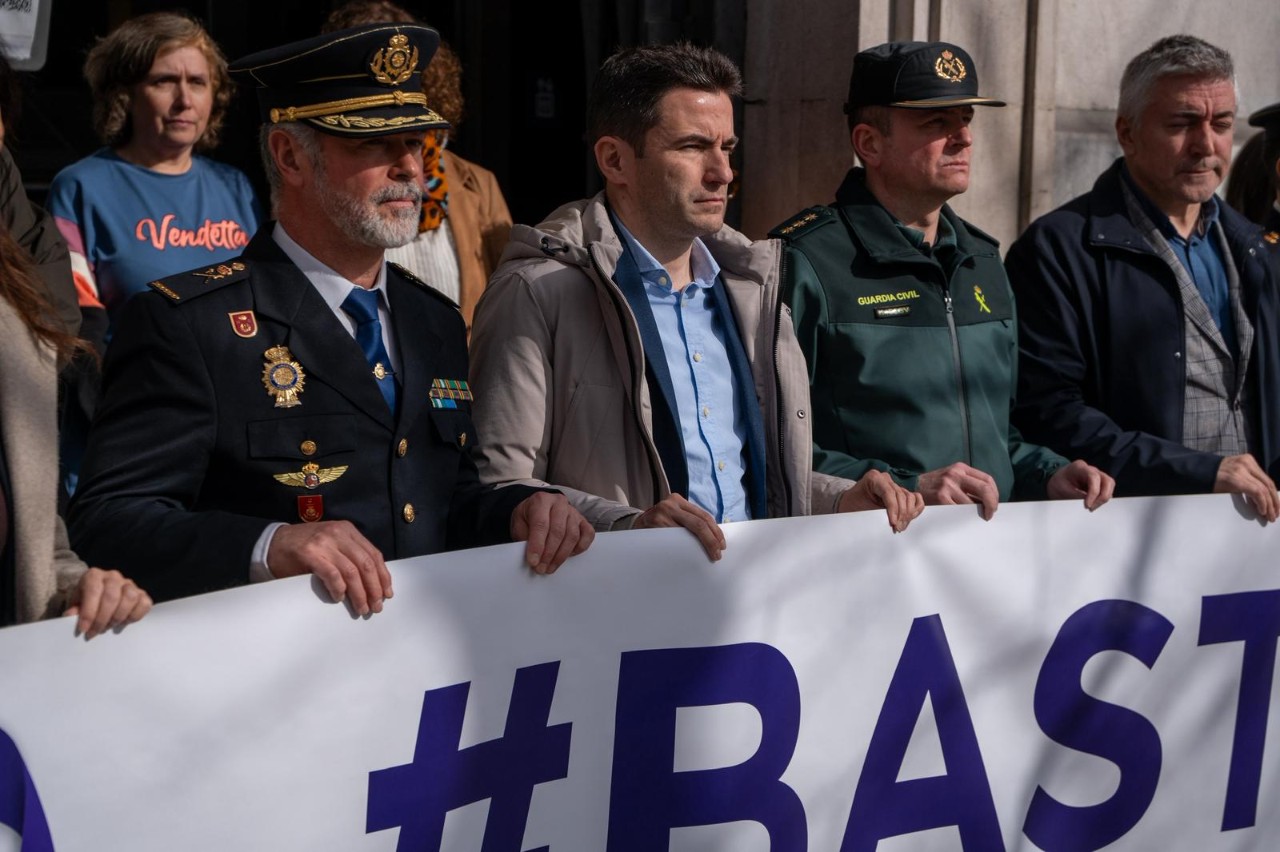El delegado junto a autoridades manteniendo la pancarta #Basta ya durante el minuto de silencio