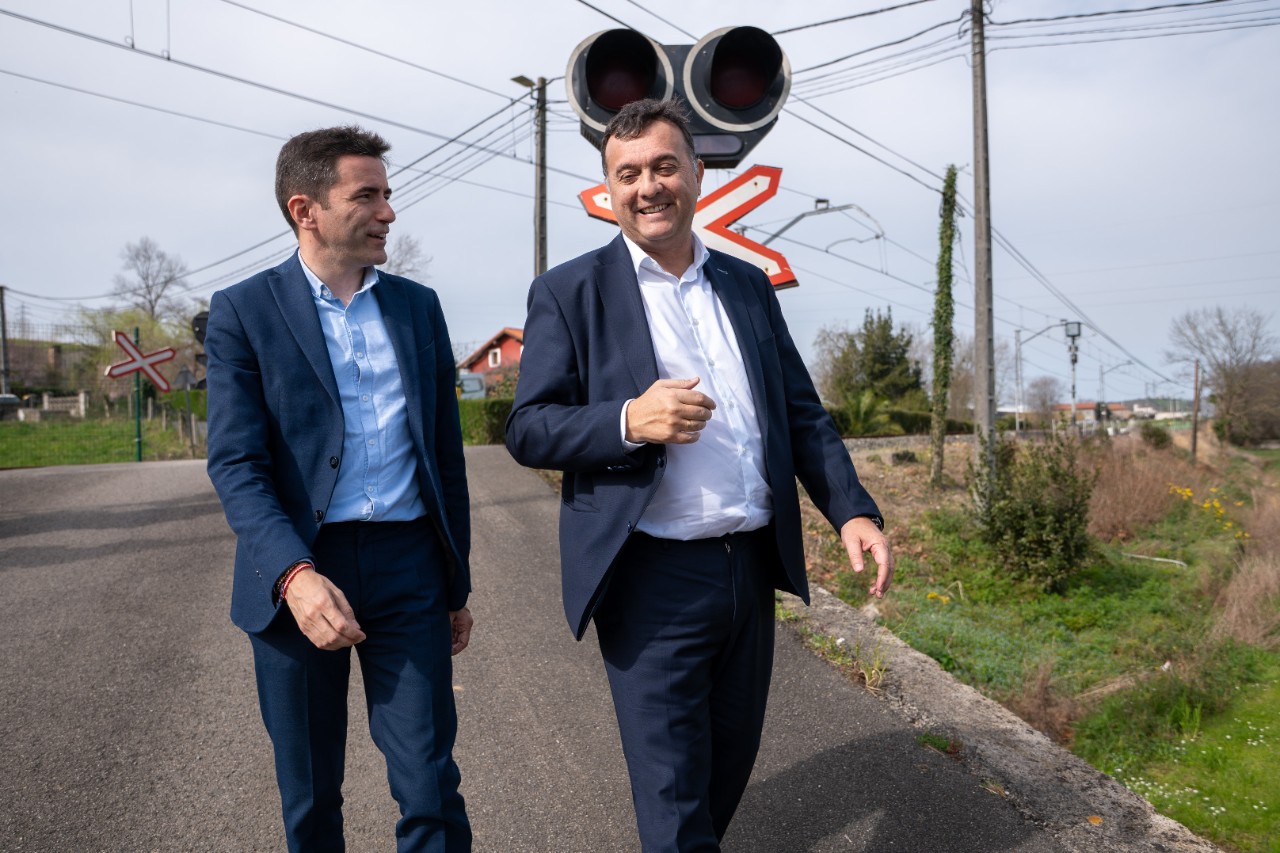 El delegado y el alcalde dando un paseo cerca del paso a nivel