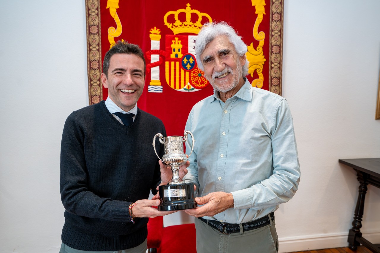 El delegado y el deportista sosteniendo el trofeo entre las manos