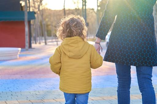 Menor caminando de la mano de su madre