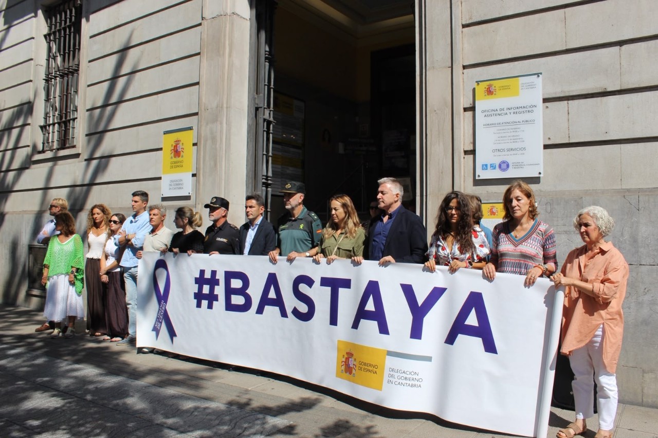 Imagen del minuto de silencio frente a la Delegación del Gobierno con la pancarta #BASTA YA