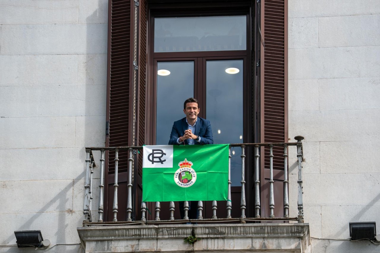 El delegado en un balcón de la Delegación en la que se ha puesto una bandera del club