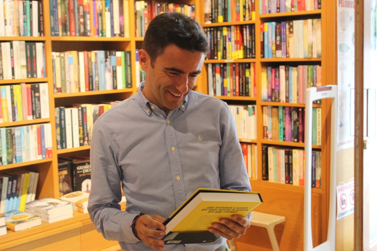 El delegado ojea un libro durante su visita a una librería