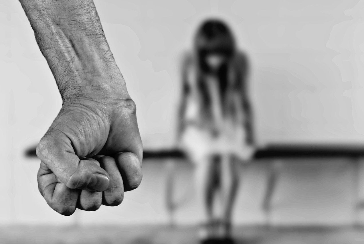 Puño amenazante con la imagen de una mujer de fondo
